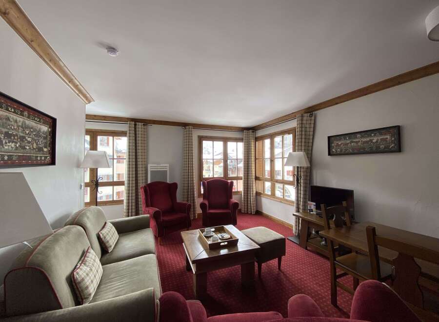 Experience cozy living in this charming mountain retreat, featuring a spacious living area with plush seating and a traditional wooden coffee table.