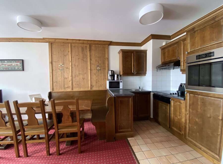 This charming kitchen and dining area features warm wooden cabinetry and a cozy built-in bench seating.