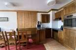 This charming kitchen and dining area features warm wooden cabinetry and a cozy built-in bench seating.