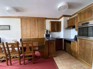 This charming kitchen and dining area features warm wooden cabinetry and a cozy built-in bench seating.