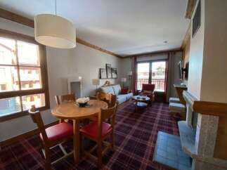 Experience cozy living in this charming apartment featuring a spacious living area with a comfortable sofa and a dining set perfect for family meals.