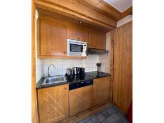 This charming kitchen features warm wooden cabinetry and a sleek granite countertop.