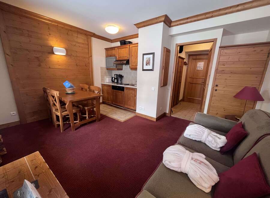 Experience cozy living in this charming apartment featuring a well-equipped kitchenette and a comfortable dining area perfect for meals.