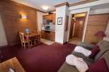 Experience cozy living in this charming apartment featuring a well-equipped kitchenette and a comfortable dining area perfect for meals.