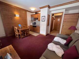 Experience cozy living in this charming apartment featuring a well-equipped kitchenette and a comfortable dining area perfect for meals.