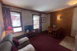 Experience cozy mountain living in this charming apartment, featuring a comfortable living area with plush seating and two plush bathrobes laid out for relaxation.