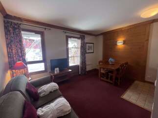 Experience cozy mountain living in this charming apartment, featuring a comfortable living area with plush seating and two plush bathrobes laid out for relaxation.