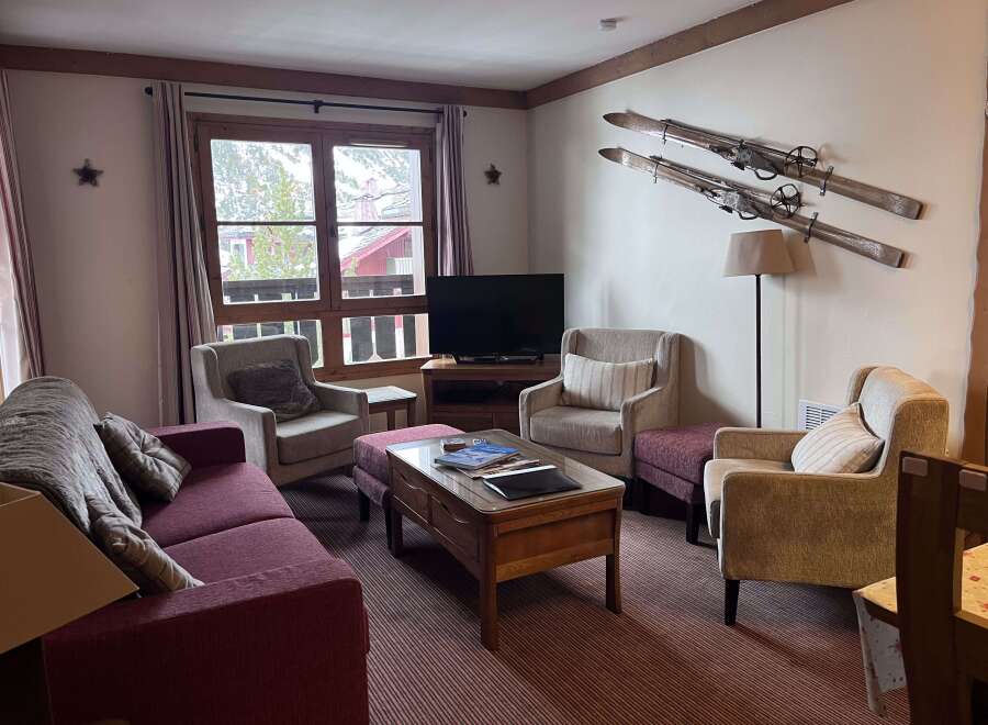 Experience cozy mountain living in this charming living room, featuring a plush sofa and comfortable armchairs perfect for relaxing after a day on the slopes.