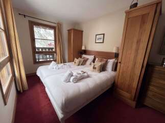 Experience cozy mountain living in this charming bedroom featuring two comfortable beds, perfect for a relaxing getaway.