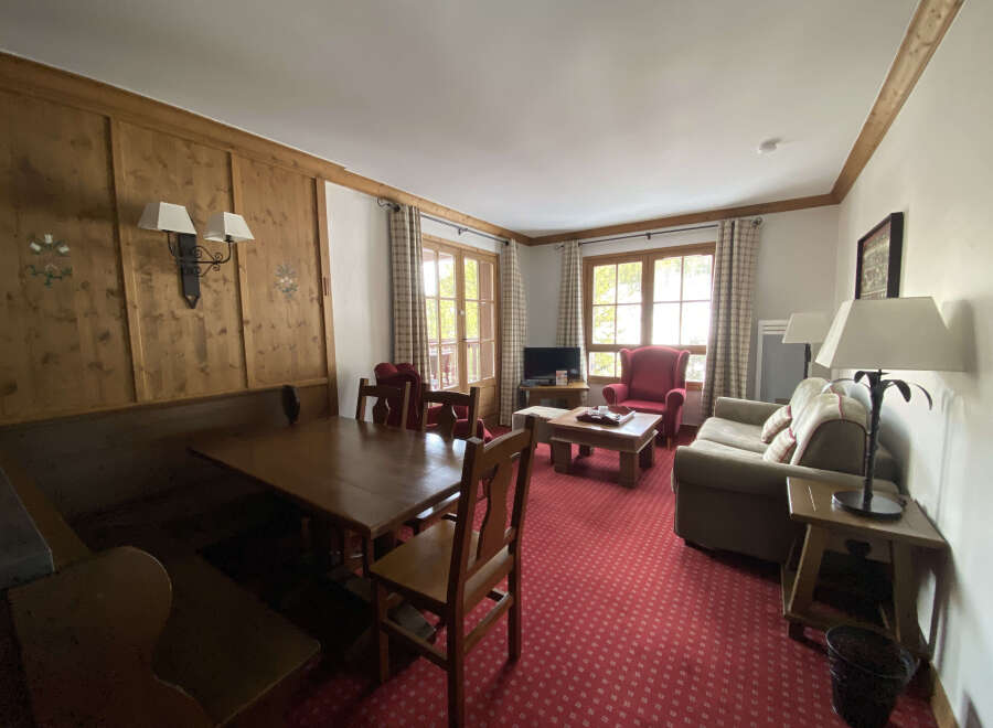 Experience cozy living in this charming apartment featuring a spacious dining area with a built-in bench and a wooden table, perfect for family meals.