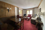 Experience cozy living in this charming apartment featuring a spacious dining area with a built-in bench and a wooden table, perfect for family meals.