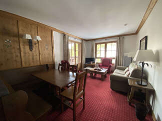 Experience cozy living in this charming apartment featuring a spacious dining area with a built-in bench and a wooden table, perfect for family meals.