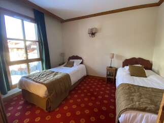 Experience cozy mountain living in this charming hotel room, featuring two comfortable twin beds perfect for solo travelers or friends.