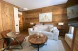 Experience rustic charm and modern comfort in this beautifully appointed living space, featuring warm wood paneling and a plush white sofa.
