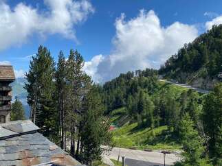 Experience breathtaking mountain views from this stunning property, nestled amidst lush green slopes and towering pine trees.