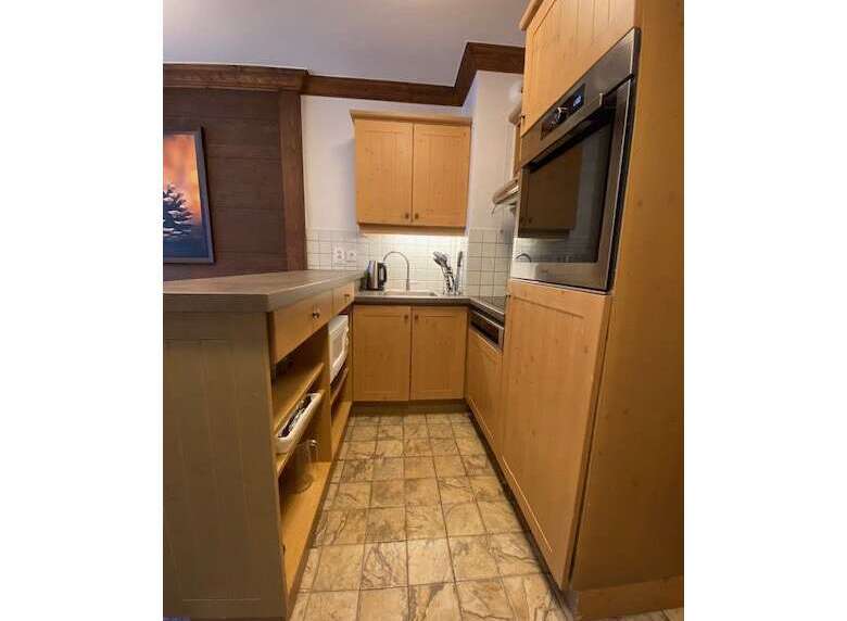Discover this charming kitchen featuring warm wooden cabinetry and a sleek built-in oven.