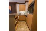 Discover this charming kitchen featuring warm wooden cabinetry and a sleek built-in oven.