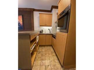 Discover this charming kitchen featuring warm wooden cabinetry and a sleek built-in oven.