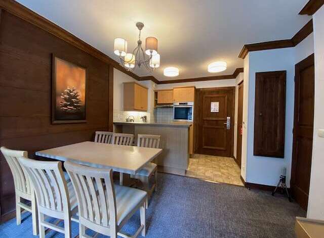 This charming dining area features a spacious wooden table with four chairs, perfect for family meals.