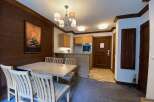 This charming dining area features a spacious wooden table with four chairs, perfect for family meals.