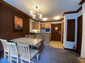This charming dining area features a spacious wooden table with four chairs, perfect for family meals.