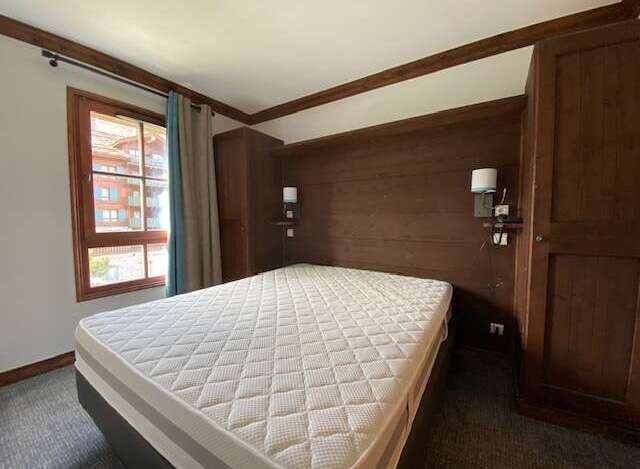 Experience cozy mountain living in this charming bedroom featuring a comfortable mattress and warm wooden accents.