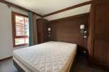 Experience cozy mountain living in this charming bedroom featuring a comfortable mattress and warm wooden accents.