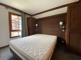 Experience cozy mountain living in this charming bedroom featuring a comfortable mattress and warm wooden accents.