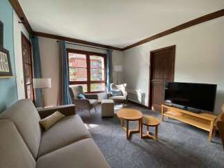 Experience comfort and style in this inviting living room, featuring a plush sofa and two cozy armchairs perfect for relaxation.