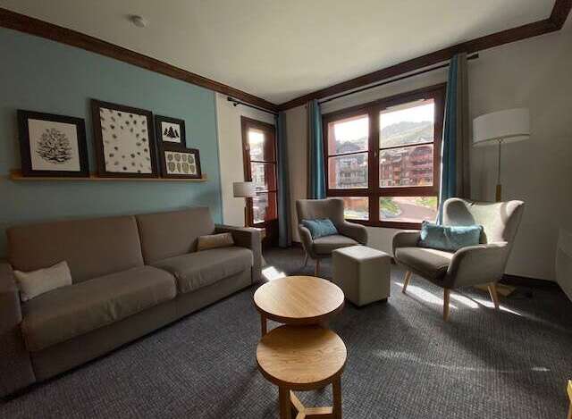 This inviting living room features a comfortable sofa and two accent chairs, perfect for relaxing after a day of skiing.