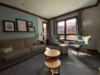 This inviting living room features a comfortable sofa and two accent chairs, perfect for relaxing after a day of skiing.