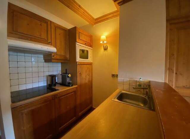 This charming kitchen features warm wooden cabinetry and a tiled backsplash, creating a cozy and functional space.