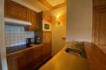 This charming kitchen features warm wooden cabinetry and a tiled backsplash, creating a cozy and functional space.