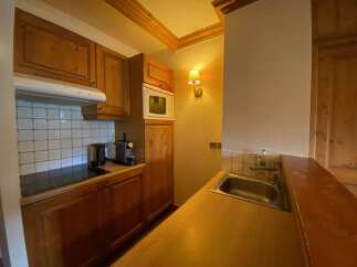 This charming kitchen features warm wooden cabinetry and a tiled backsplash, creating a cozy and functional space.