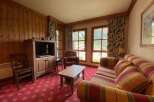 Experience cozy living in this charming room featuring a rustic wooden entertainment center with a television and ample storage.