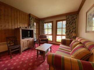 Experience cozy living in this charming room featuring a rustic wooden entertainment center with a television and ample storage.