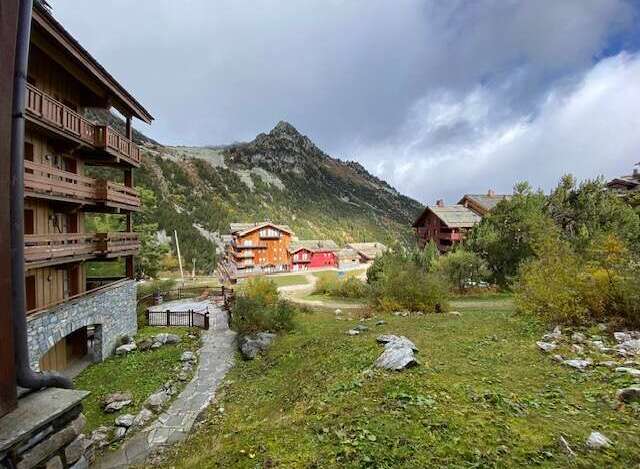Experience mountain living in this charming alpine village setting, featuring traditional wooden chalets nestled against a backdrop of majestic peaks.