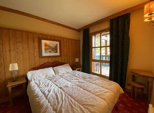 Experience cozy comfort in this charming bedroom, featuring a plush bed adorned with crisp white linens.