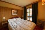 Experience cozy comfort in this charming bedroom, featuring a plush bed adorned with crisp white linens.