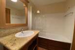 This charming bathroom features a spacious bathtub with a glass enclosure, perfect for relaxing soaks.