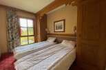 Experience comfort and style in this charming bedroom featuring two inviting beds, perfect for families or groups.