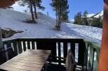 Enjoy breathtaking mountain views from this charming balcony, complete with a rustic wooden table and chairs.