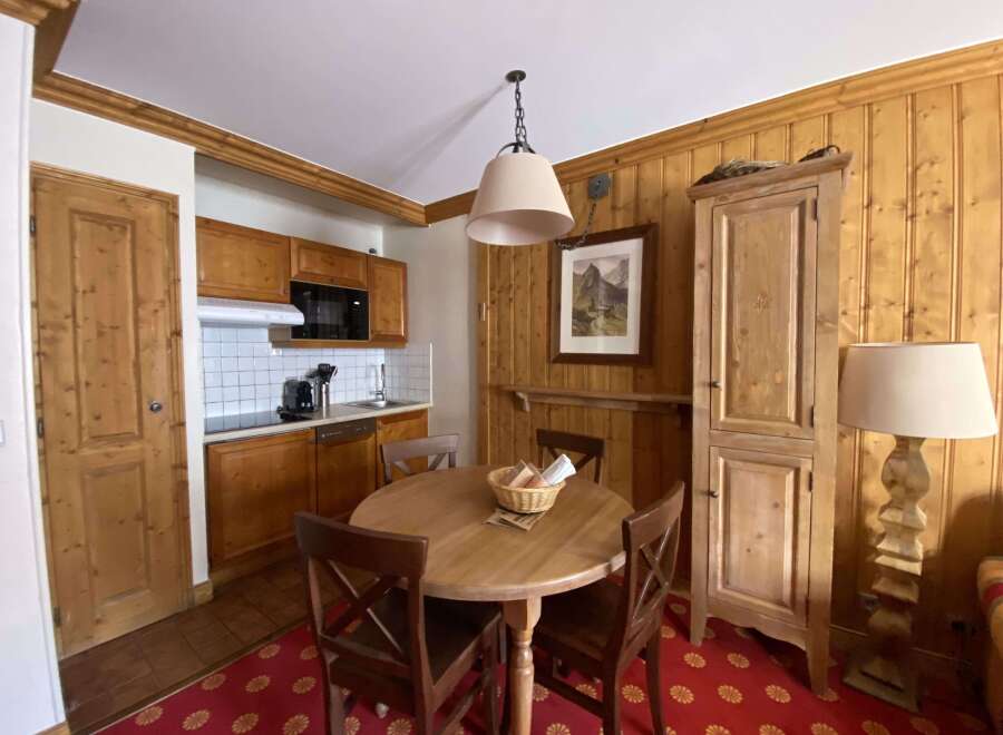 This charming dining area features a rustic wooden table with four chairs, perfect for intimate meals.