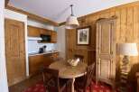 This charming dining area features a rustic wooden table with four chairs, perfect for intimate meals.