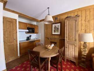 This charming dining area features a rustic wooden table with four chairs, perfect for intimate meals.