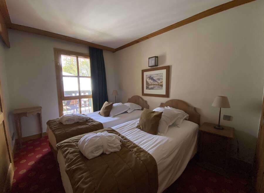 Experience comfort and tranquility in this charming hotel room, featuring two cozy twin beds perfect for a restful night's sleep.