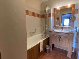 This charming bathroom features a classic bathtub with a shower, perfect for relaxing after a long day.
