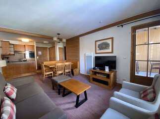 This charming living space features a cozy dining area with a wooden bench and chairs, perfect for family meals.