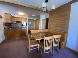 This charming apartment features a cozy dining area with a wooden table and chairs, perfect for family meals.