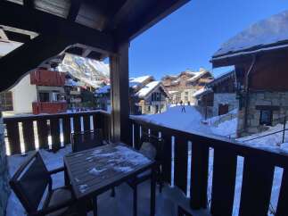 Experience the charm of a winter wonderland from your private balcony, complete with a table and chairs dusted with snow.